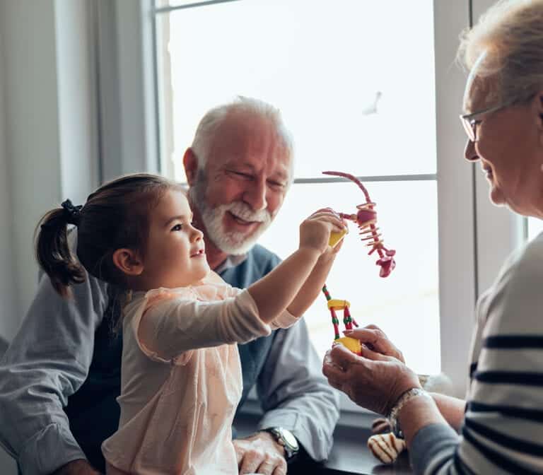 Grandparents playing with their granddaughter