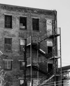 Vintage Multi Story Brick Building With Boarded Up Windows