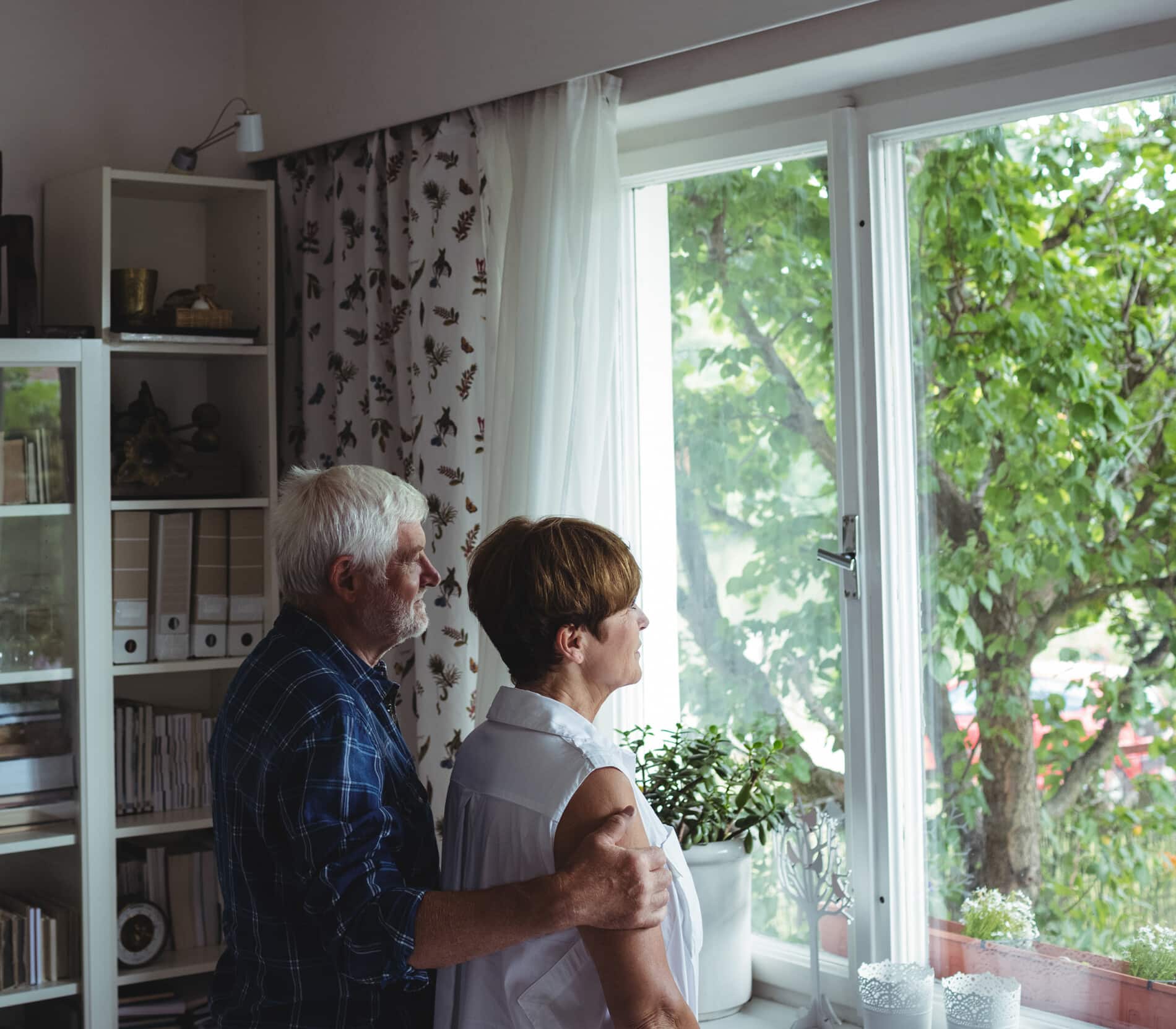 Senior couple looking through window