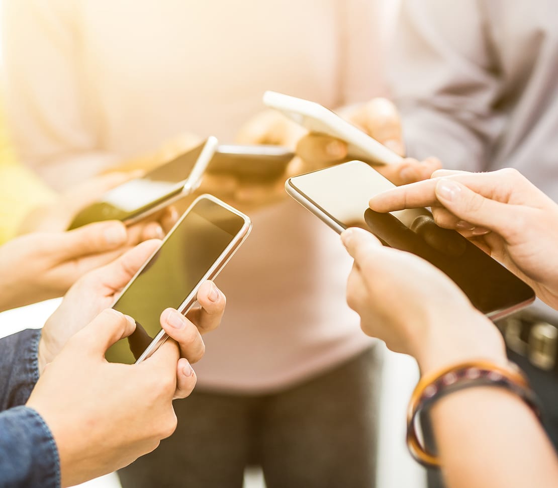 Friends having fun together with smartphones.