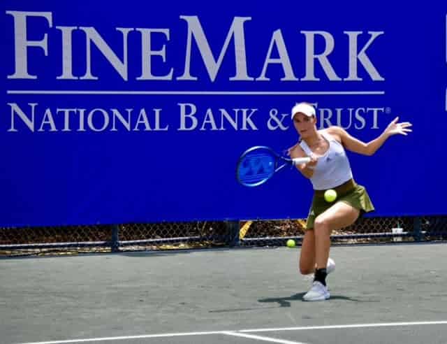 female tennis playing hitting ball