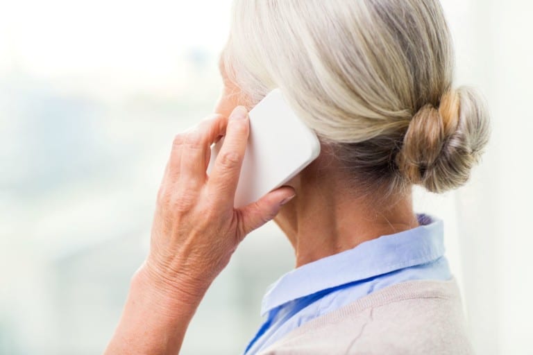 Senior woman on mobile device listening to call