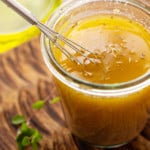 Homemade vinaigrette salad dressing with olive oil, vinegar and herbs