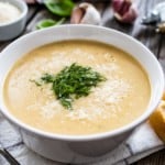 Cream garlic and parmesan soup on wooden table