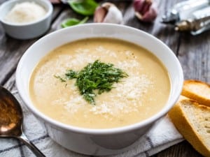 Cream garlic and parmesan soup on wooden table