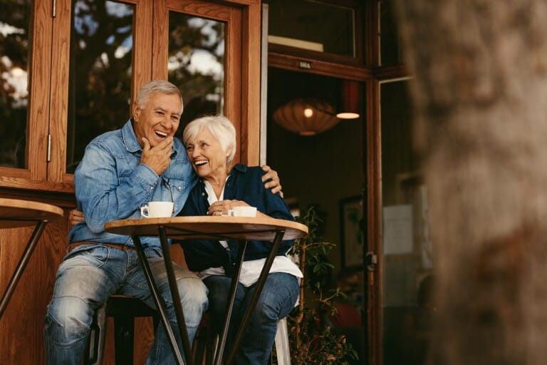 Senior couple in love sitting in cafe talking and having fun. Happy retirement couple relaxing at coffee shop.