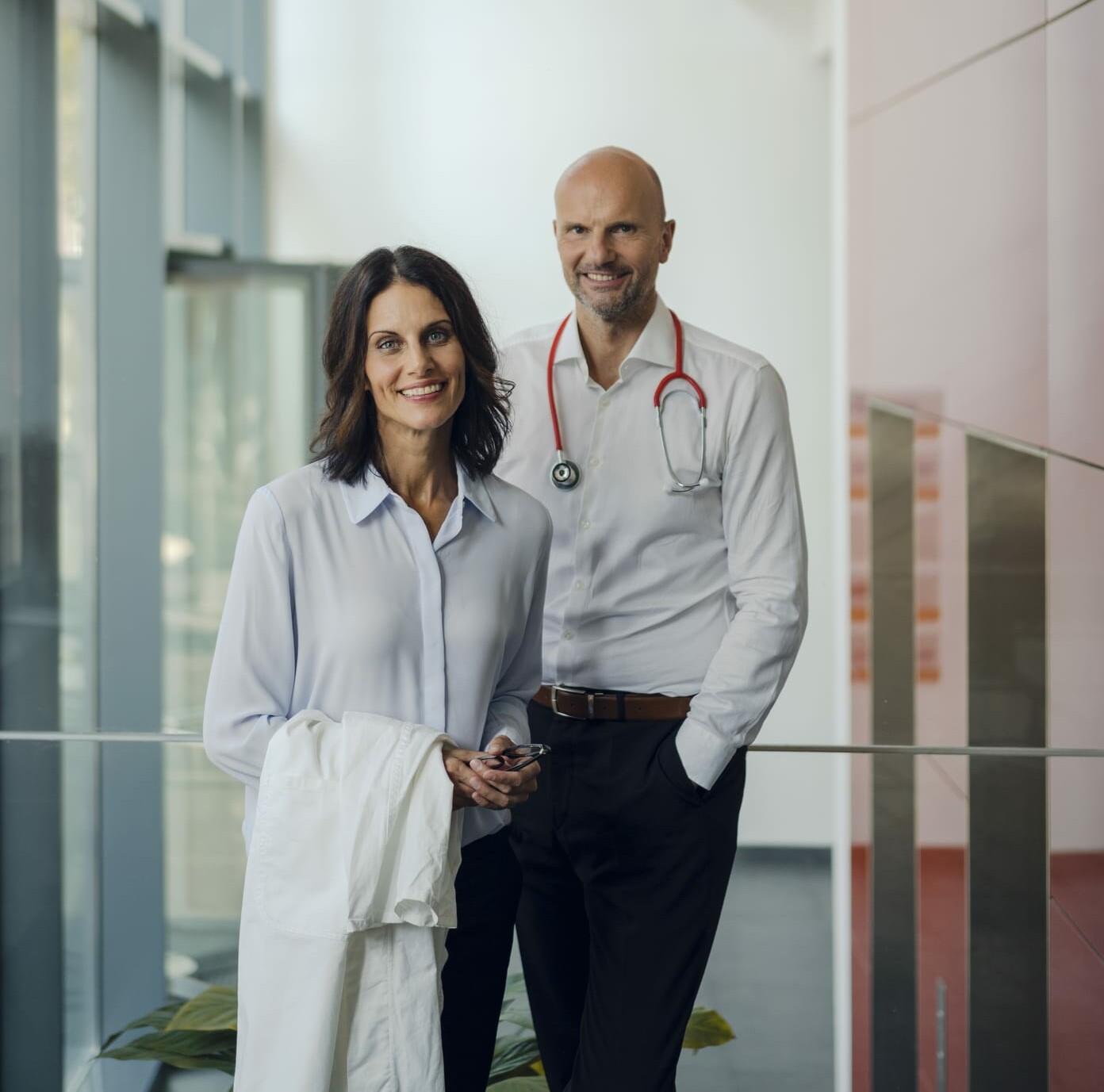 Friendly doctors standing in hospital, smiling