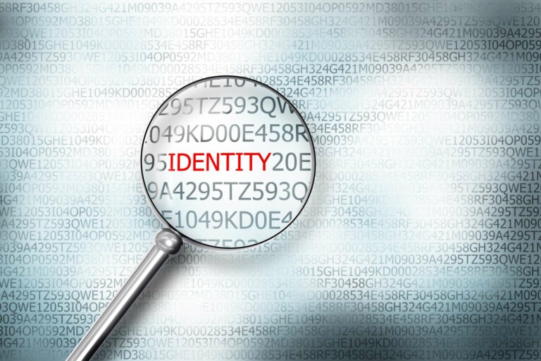 reading the word identity on computer screen with a magnifying glass internet security