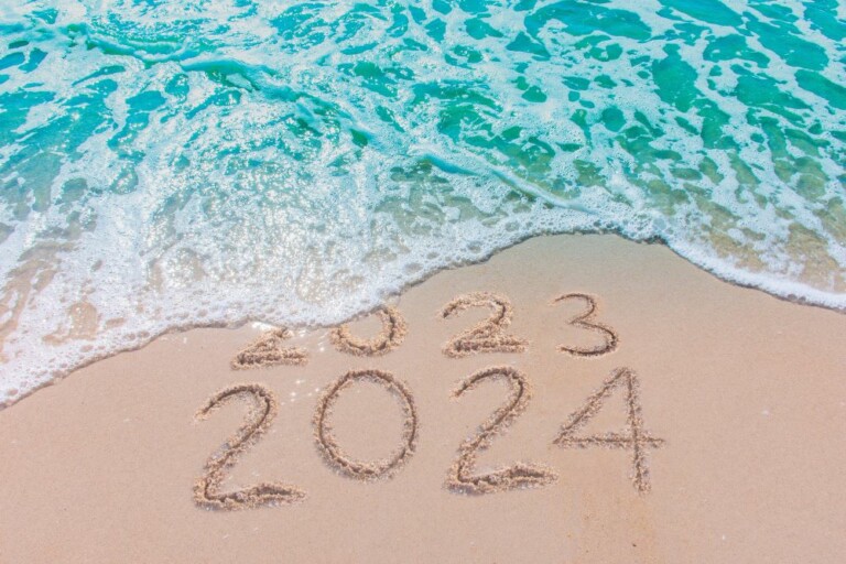 Message Year 2023 replaced by 2024 written on beach sand background