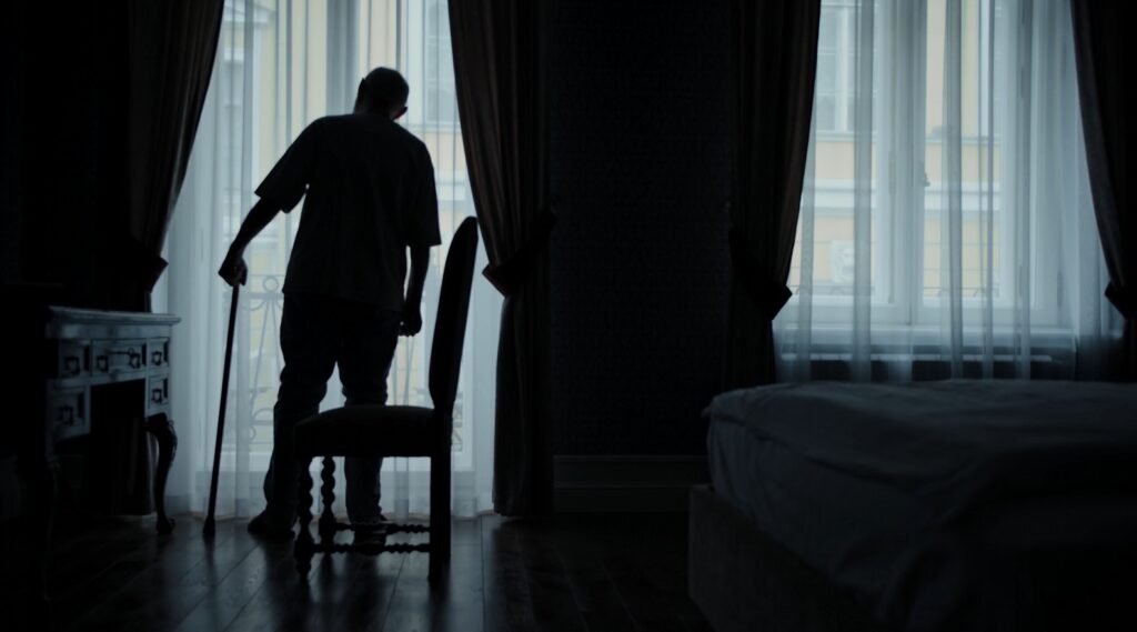 senior man looking out window