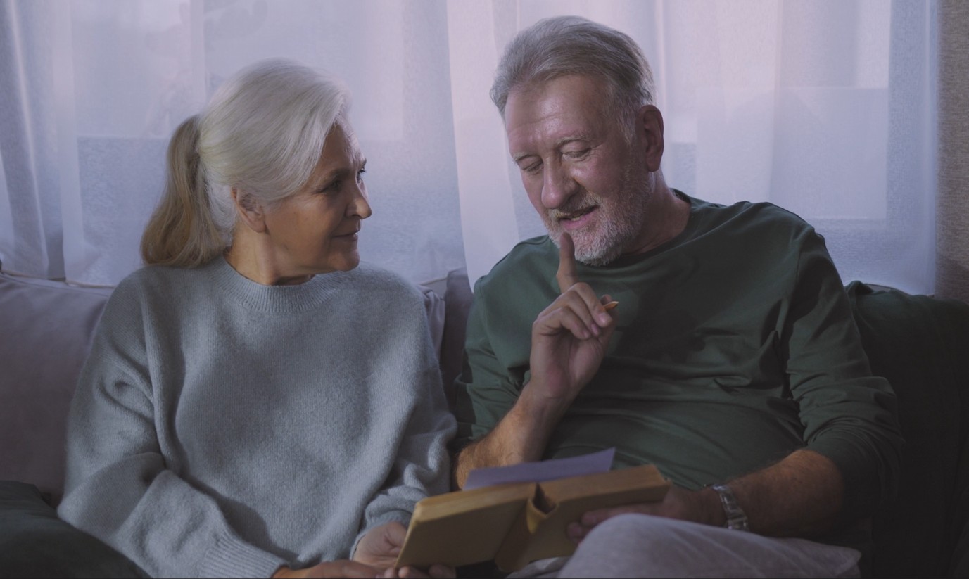 senior couple talking on couch