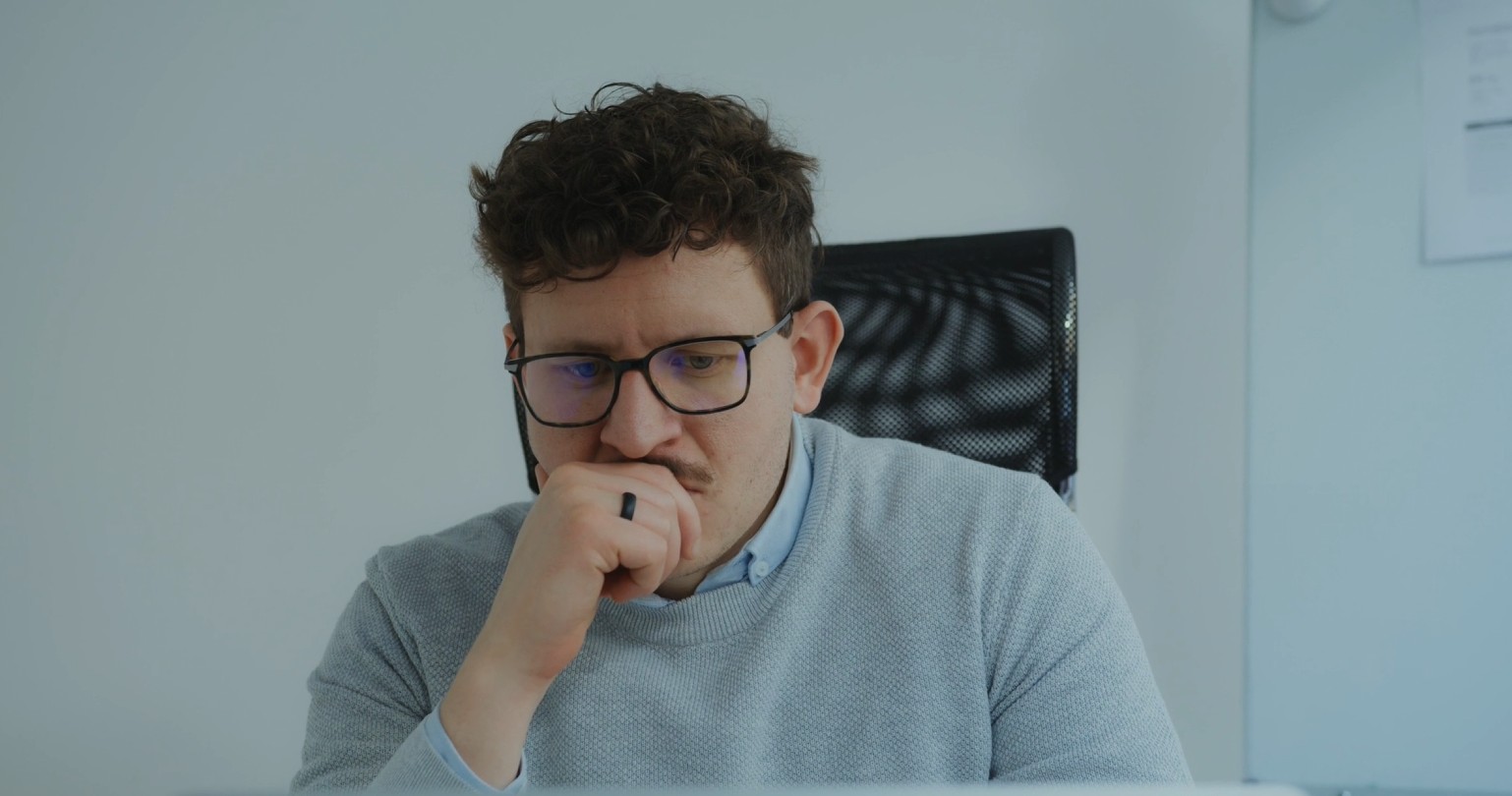 worried man looking at computer pensively