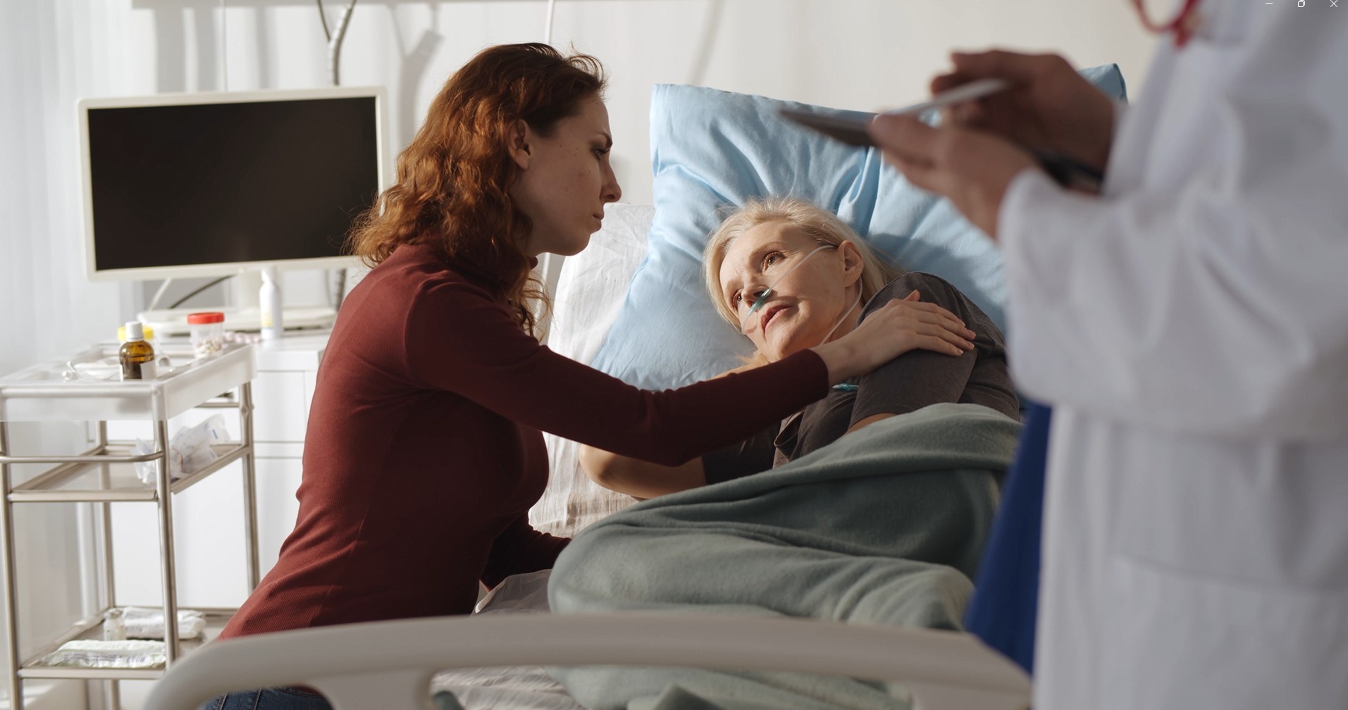 Senior Woman in Hospital Bed with Adult Daughter next to her